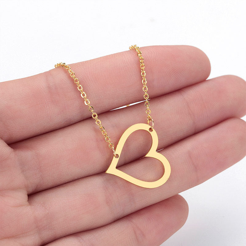 a person holding a heart shaped necklace in their hand