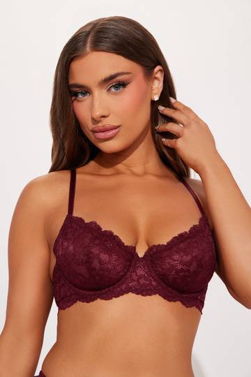 a woman wearing a burgundy bra and panties