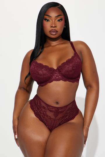 a woman wearing a burgundy lingerie and panties