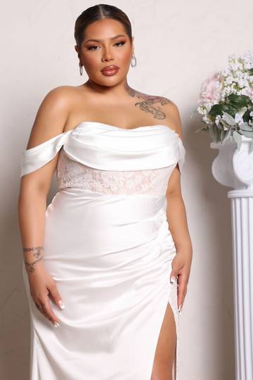 a woman in a white dress with a thigh high slit