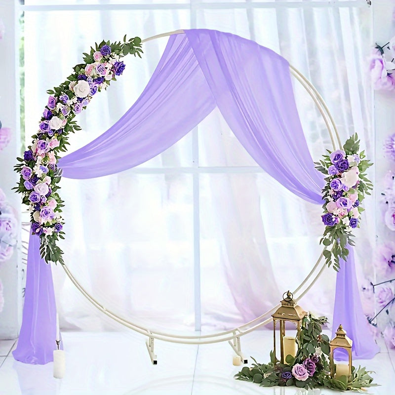 a wedding arch decorated with purple flowers and greenery