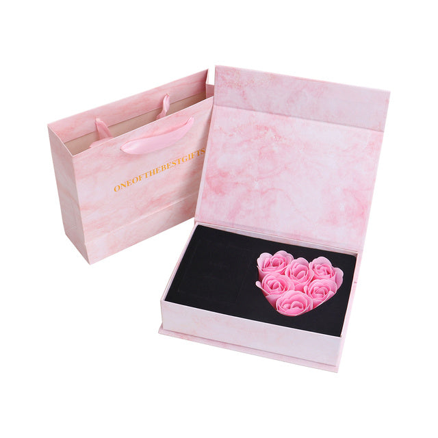 a pink gift bag with pink roses in it