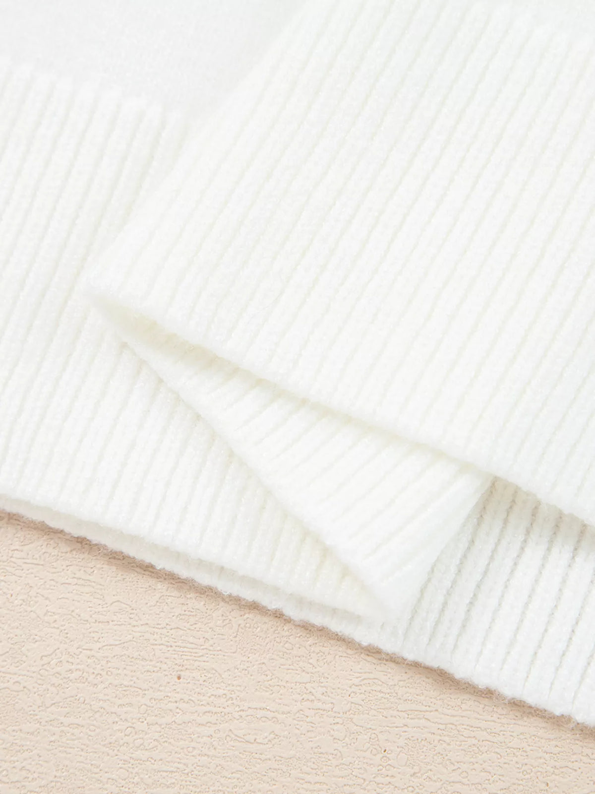 Close-up of the ribbed cuffs of the MERRY Letter Pattern Christmas Raglan Sleeve Sweater in white.