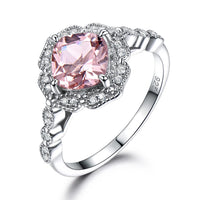 a ring with a pink stone surrounded by white diamonds