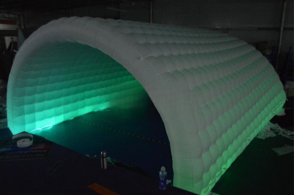 an inflatable arch is lit up with green light