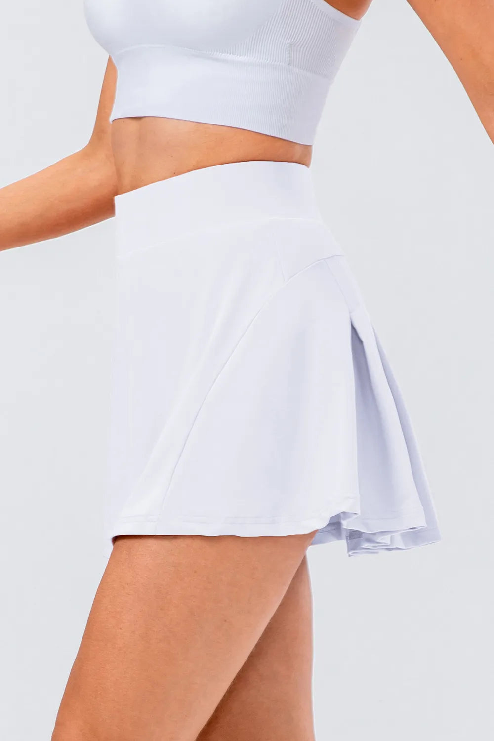 High waist pleated active skirt in light color, showcasing a stylish look and stretch fabric design.