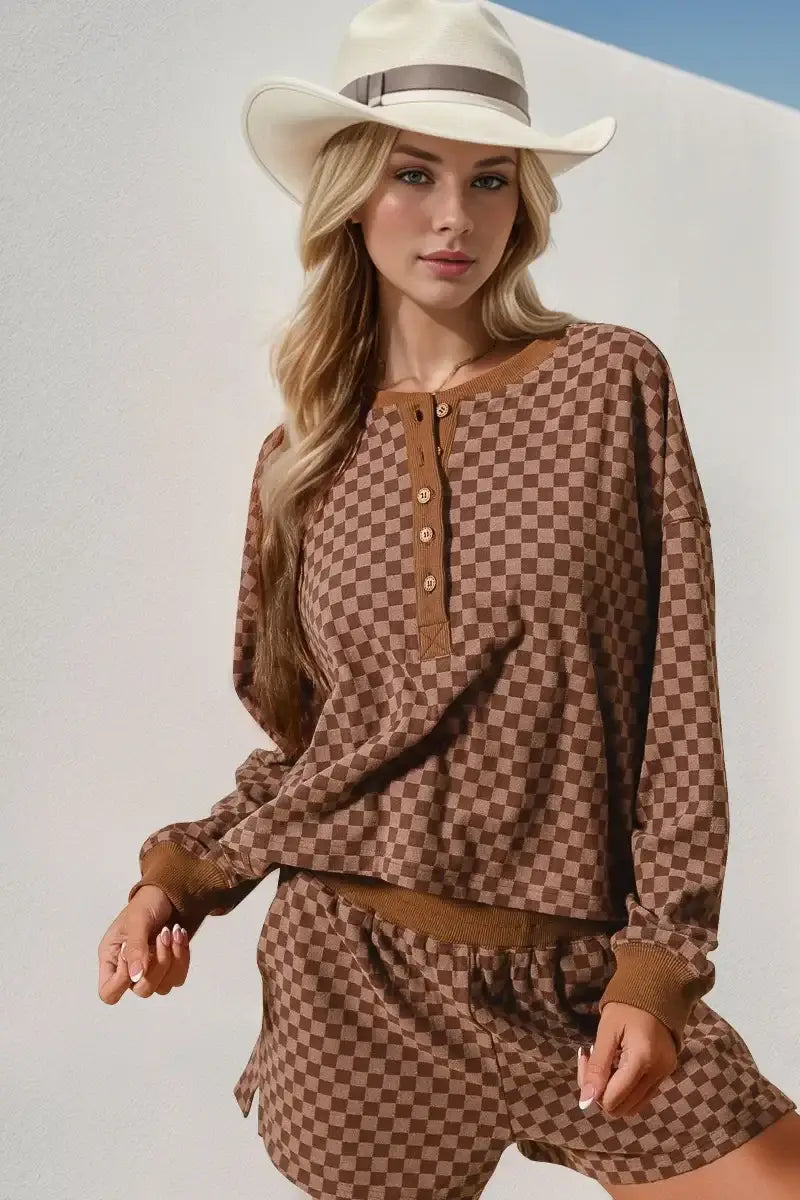 Brown checkered half button top paired with matching shorts, styled with a wide-brimmed hat.