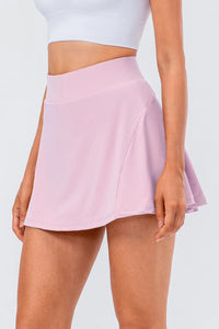 High waist pleated active skirt in soft pink, showcasing a flattering fit and flowy design for active wear.