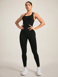 Model wearing a black crisscross back sleeveless active jumpsuit with white sneakers.