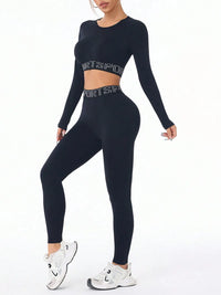 Black letter print long sleeve crop top and leggings activewear set, ideal for workouts and casual wear.