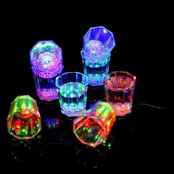 a group of colorful lights up glasses on a table