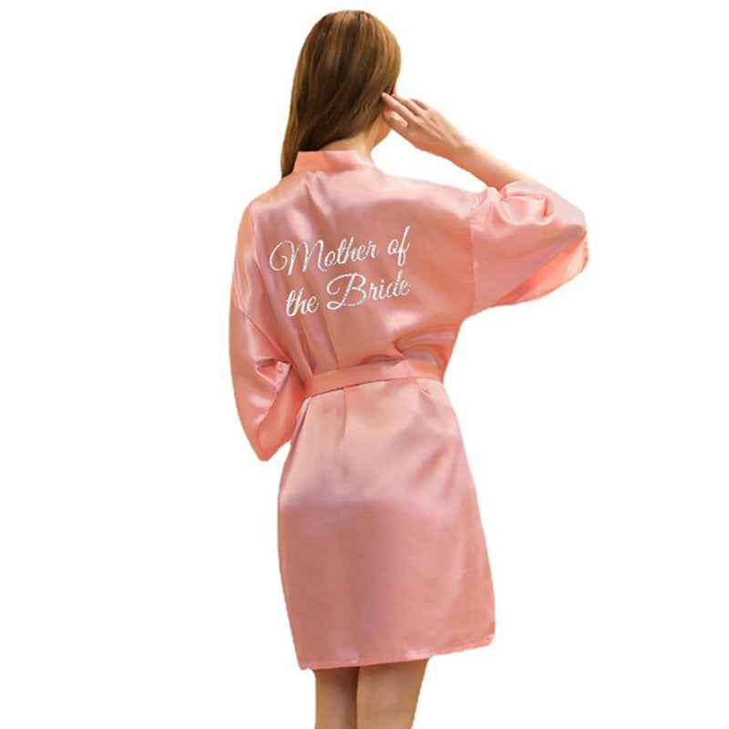 a woman in a pink robe with the words mother of the bride on it