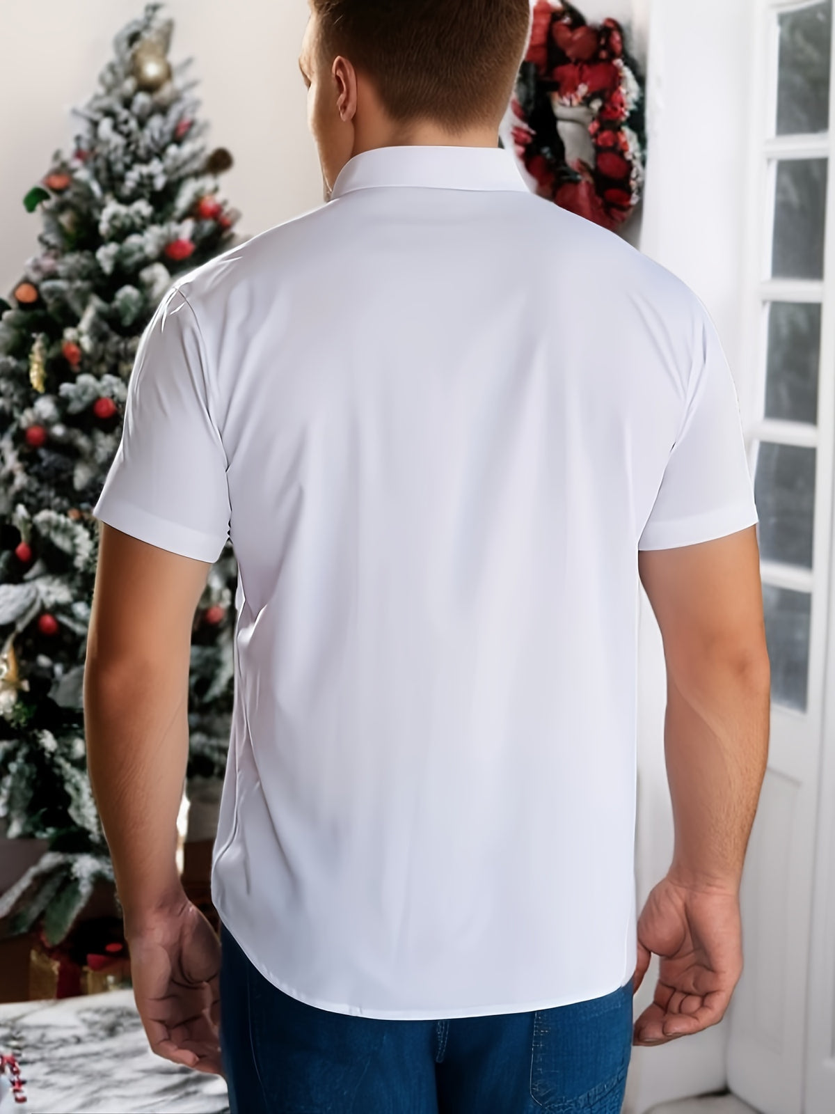 a man standing in front of a christmas tree