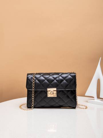 a black purse sitting on top of a white table