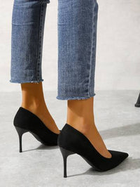 a woman's legs wearing high heels and jeans