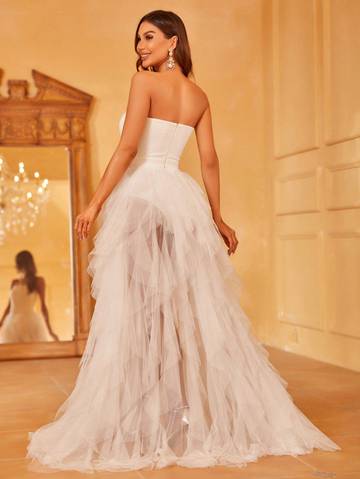 a woman in a wedding dress standing in front of a mirror