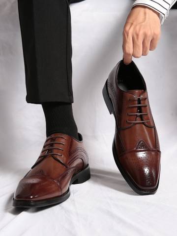 a man in black pants and a brown shoe