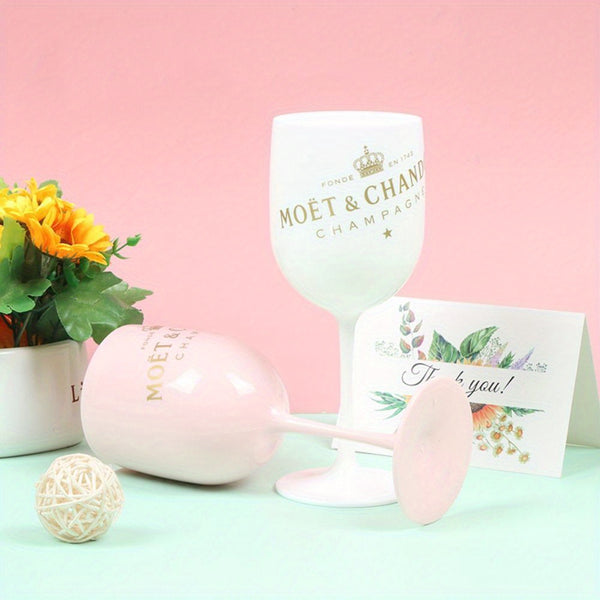 a pink wine glass next to a white wine goblet