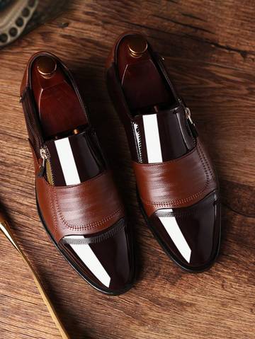 a pair of brown shoes sitting on top of a wooden table