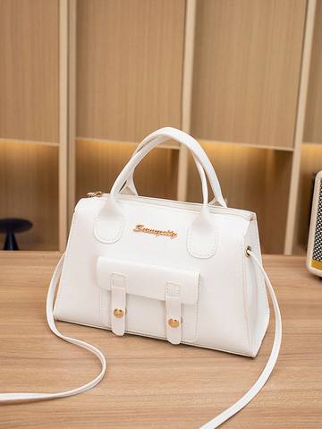 a white purse sitting on top of a wooden table