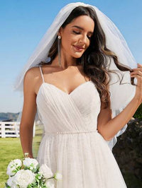 a woman in a wedding dress holding a bouquet of flowers