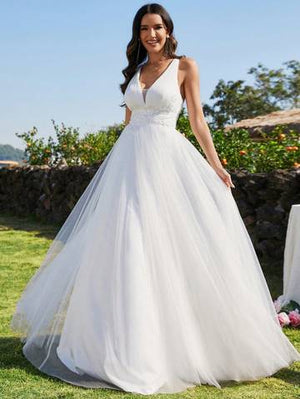 a woman in a white wedding dress standing in the grass