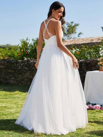 a woman in a white dress standing in the grass