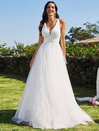 a woman in a white dress standing in the grass