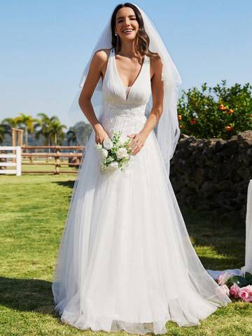 a woman in a wedding dress standing in the grass