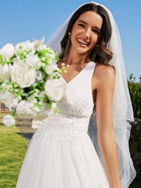 a woman in a wedding dress holding a bouquet of flowers