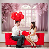 a man and woman sitting on a red couch with red balloons