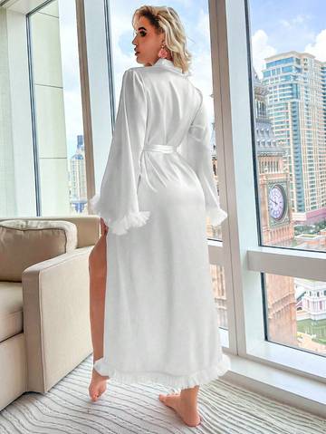 a woman in a white robe standing in front of a window