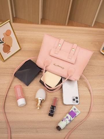 a pink purse sitting on top of a wooden table