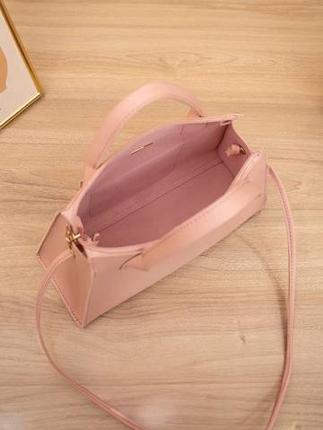 a pink purse sitting on top of a wooden table