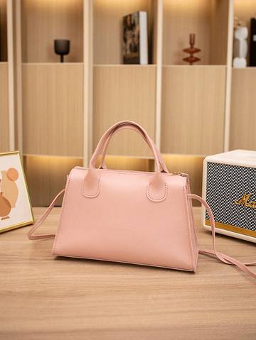 a pink purse sitting on top of a wooden table