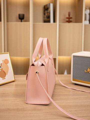 a pink purse sitting on top of a wooden table