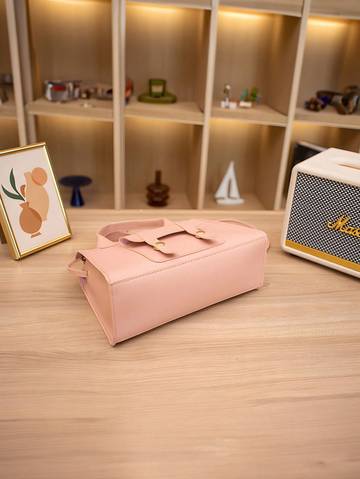 a pink suitcase sitting on top of a wooden table