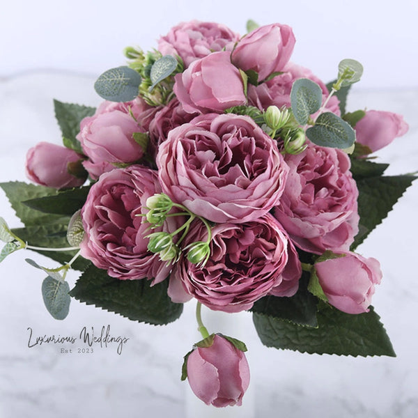 a bouquet of pink flowers sitting on top of a table