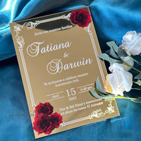 a gold wedding card with red roses on it