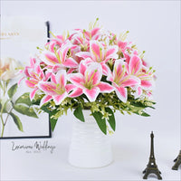 a white vase filled with pink flowers next to a miniature eiffel tower