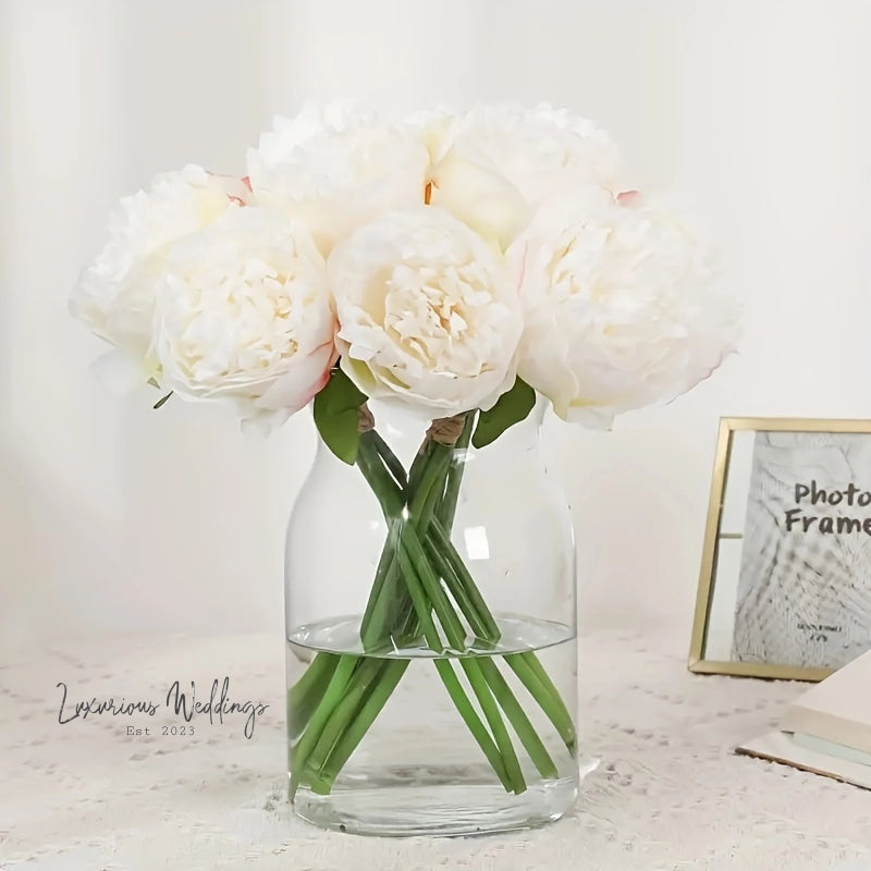 a glass vase filled with white flowers on top of a table