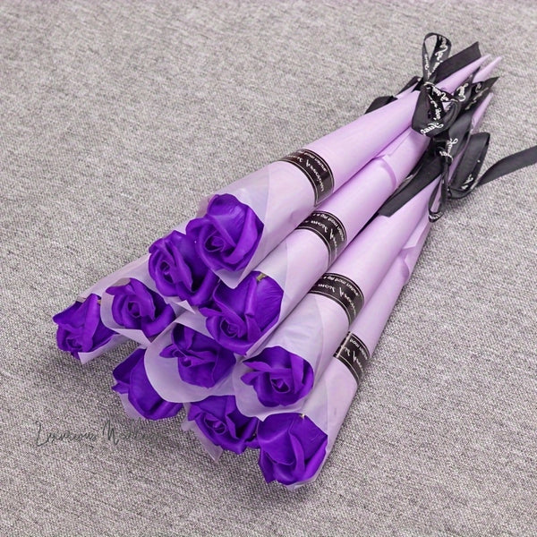 a bunch of purple roses tied to a black ribbon