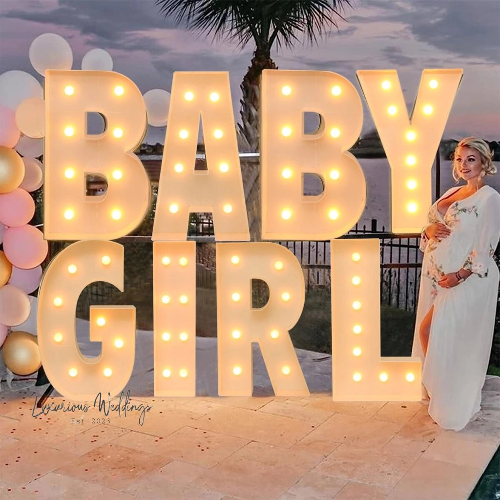 a woman standing in front of a sign that says baby girl