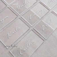 clear acrylic business cards with white writing on them