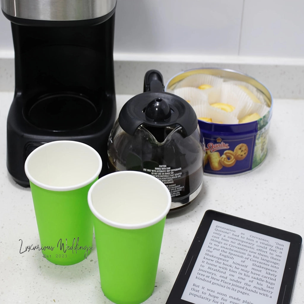 a tablet sitting on top of a counter next to two cups