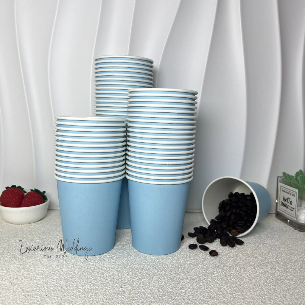 a stack of blue cups sitting next to a bowl of coffee beans