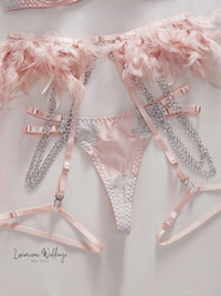 a pink bra and panties with feathers on them