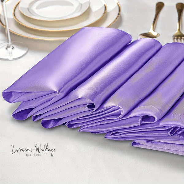 a table set with purple napkins and silverware