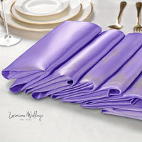 a table set with purple napkins and silverware