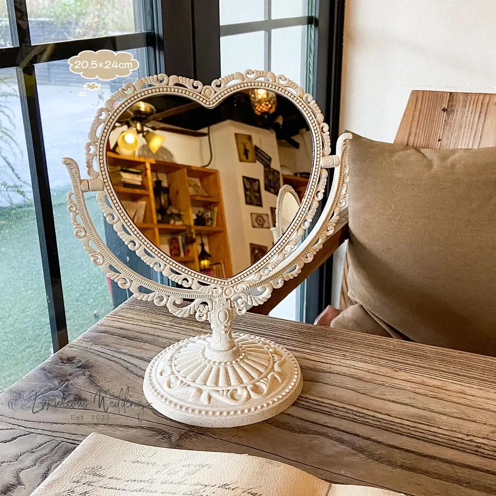 a heart shaped mirror sitting on top of a wooden table